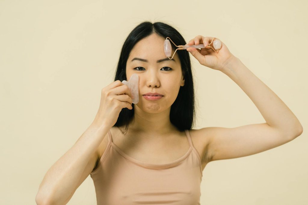 Femme se massant le visage avec deux produits cosmétiques