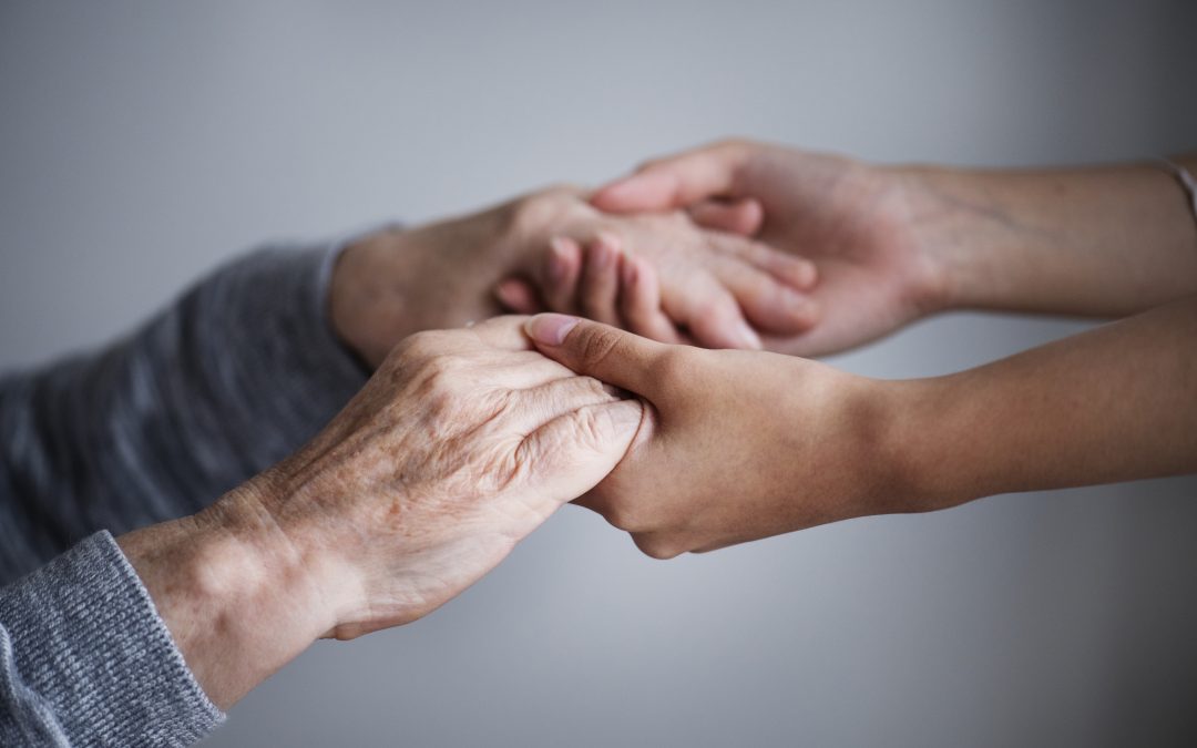 les mains d'une personne âgée dans les mains d'une jeune femme